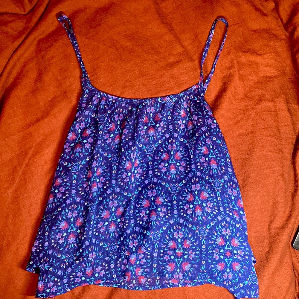 Blue flowy tank top with spaghetti straps.